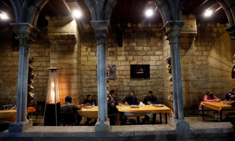 People eat during a charity Ramazan dinner in the cloister at Santa Anna church during the coronavirus outbreak, in Barcelona, Spain on April 28. — Reuters