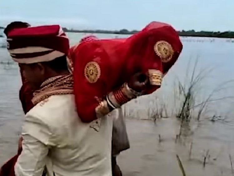 VIDEO: Groom carries bride on shoulders across a flooded river